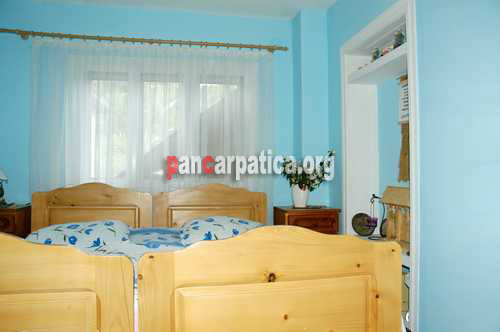 Imagine a dormitorului incapator cu 2 paturi simple confortabile din Gambita-Botiza