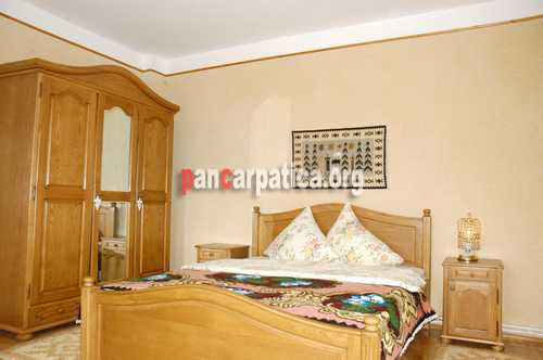 Imagine camera frumoasa cu pat matrimonial in interiorul Casei Bobocea-Poienile Izei