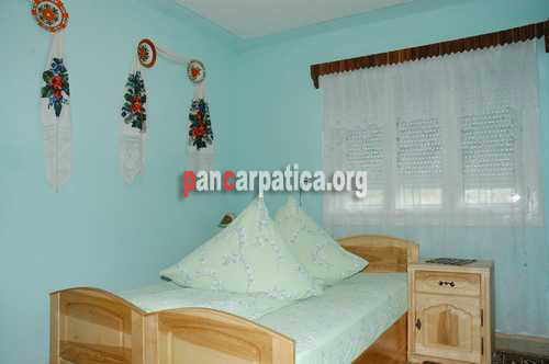 Imagine dormitor elegant cu mobilier de lemn, cu 2 paturi simple in pensiunea Maria si Victor-Poienile Izei