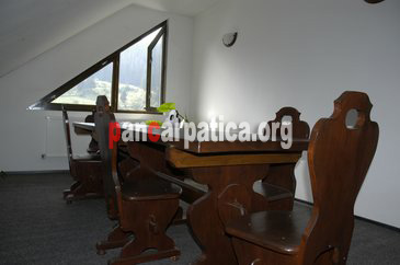 Imagine mansarda cu mobilier modern, scaune si masa din lemn, la pensiunea Casa Calin din Vama