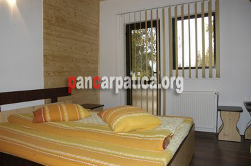 Imagine camera spatioasa cu pat matrimonial comod in interiorul pensiunii Cris din Vatra Dornei