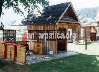 Imagine curte interioara cu foisor din lemn si fantana traditionala in cadrul pensiunii La Gorita din Vama