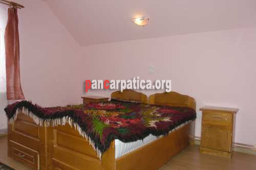 Imagine cu interiorul unui dormitor cu 2 paturi simple a pensiunii Costinar Aurica din Botiza