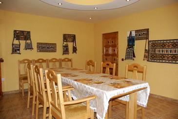 Imagine living cu 12 locuri in Casa Sidau din Botiza cu mese din lemn unde turistii pot servi mses copioase si savuroase