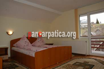 Imagine a dormitorului cu pat matrimonial din pensiunea Maria-Durau cu balcon cu vedere spre muntii Ceahlau