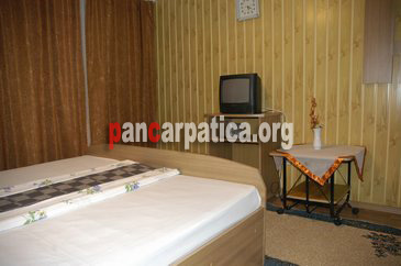 Imagine camera cu pat matrimonial mare si elegant in interiorul pensiunii Lido din Moisei