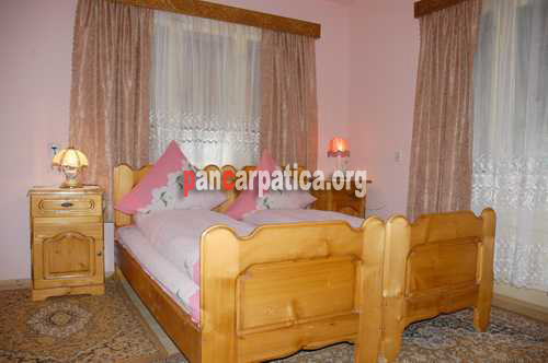 Imagine dormitor spatios cu 2 paturi simple confortabile in cadrul pensiunii Poienar-Botiza