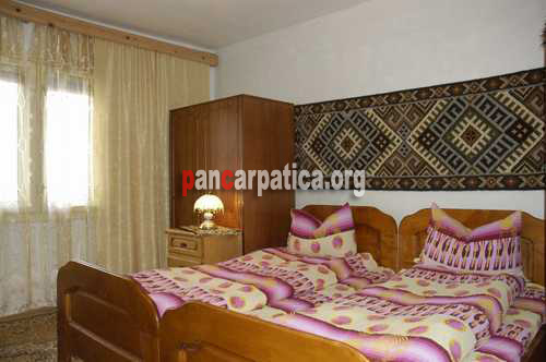 Imagine dormitor cu 2 paturi simple din pensiunea Poienar-Botiza plin de traditie maramureseana