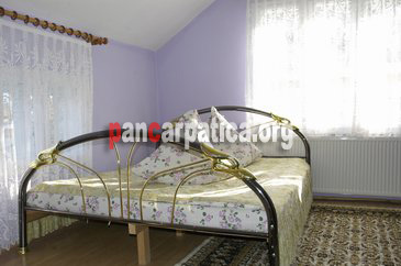 Imagine camera spatioasa in interiorul pensiunii Monica din Vatra Dornei, cu pat matrimonial mare