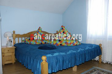 Imaginea unei camere cu pat matrimonial mare si curat, in interiorul pensiunii Monica din Vatra Dornei