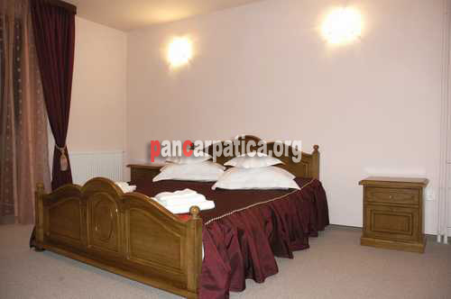 Imagine dormitor spatios cu pat matrimonial elegant si comod in pensiunea Valcan din Vatra Moldovitei