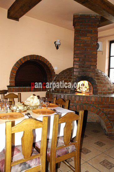 Imagine restaurant in interiorul pensiunii Casa Bucovineana din Vatra Dornei decorat cu scaune si mese din lemn