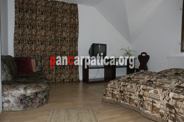 Imagine camera cu pat matrimonial si sofa comoda, in interiorul pensiunii Casa Calin din Vama
