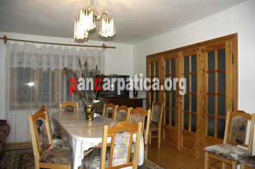 Imagine a livingului din interiorul pensiunii Casa Cristi situata in Sucevita, cu mese si scaune frumos decorate