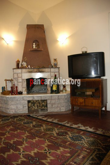 Imagine cu livingul si semineul din interiorul pensiunii La Gorita-Vama modern si bine echipat