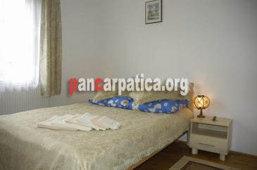 Imagine camera decorata cu bun gust, cu mobilier elegant si pat matrimonial mare in pensiunea Bucovina din Gura Humorului