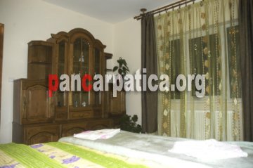 Imagine a interiorului din dormitorul primitor si cu paturi confortabile din pensiunea Dorina-Botiza