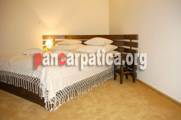 Imaginedormitor cu pat matrimonial comod si mare din interiorul pensiunii Inima Bucovinei-Frasin