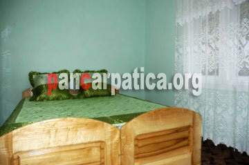 Imagine a dormitorului cu pat matrimonial din pensiunea Mariana-Botiza comod, simplu si elegant