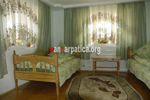 Imagine interior a unui dormitor cu 2 paturi simple comode in pensiunea Alex din Manastirea Humorului