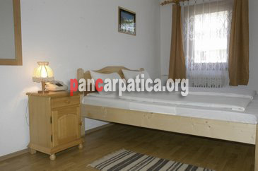 Imagine dormitor elegant cu pat matrimonial mare si curat in pensiunea Calimanel din Vatra Dornei