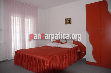 Imagine cu interiorul unui dormitor cu pat matrimonial din pensiunea Obcina Mare-Gura Humorului