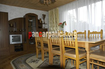Imagine living cu tv, masa si scaune din lemn, mobilier modern in interiorul pensiunii Harieta din Agapia