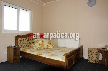 Imagine camera eleganta si curata cu un pat simplu in interiorul Hotelului La Galan din Radauti