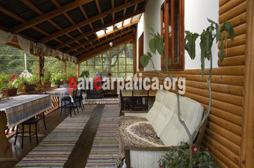 Imagine terasa acoperita bine echipata, cu scaune si mese din lemn, cu o capacitate de 16 locuri in interiorul pensiunii Emilia din Sucevita