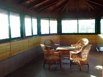 Imagine salon cu mese si scaune, frumos amenajat in interiorul pensiunii Iristar din Falticeni