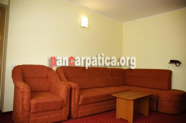 Imagine dormitor cu canapea mare, fotolii confortabile, masa din lemn in pensiunea Vanatorul din Vatra Dornei