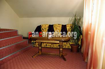 Imagine interior in pensiunea Katerina din Vatra Dornei cu canapea eleganta si masa din lemn
