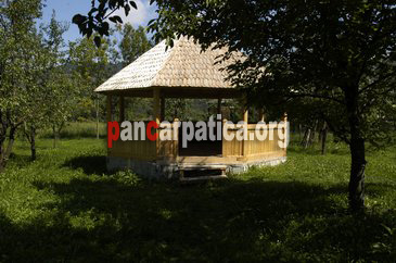 Imagine cu foisorul din lemn al pensiunii Sub Cetate la Matei-Oncesti unde oaspetii se pot relaxa in aer liber si servi masa in natura