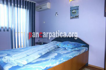 Imagine dormitor cu pat matrimonial din pensiunea Lebada-Bicaz curat, elegant si cu geamuri orientate catre zona montana si spre lac