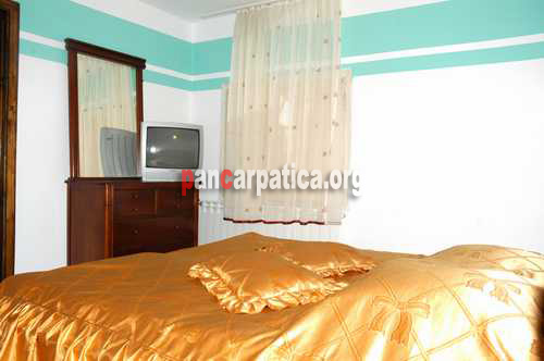 Imagine dormitor cu televizor si un pat matrimonial spatios si comod la pensiunea Casa Lucan din Vama