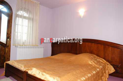 Imagine cu interiorul dormitorului cu pat matrimonial a pensiunii foarte primitoare, Casa Lucan din Vama