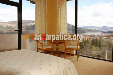 Imagine camera cu pat matrimonial cu vedere spre muntii Ceahlaului in interiorul Vilei Ecotur