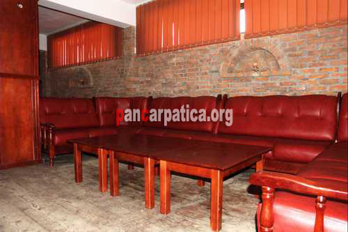 Imagine cu interiorul discotecii din pensiunea Poiana-Putna cu mese din lemn si canapele confortabile