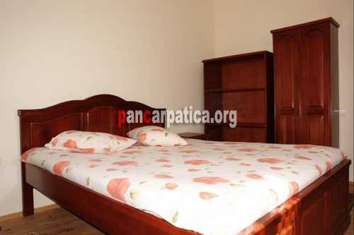 Imagine dormitor cu pat matrimonial din Cabana Poiana-Putna de unde poti admira feeria muntilor